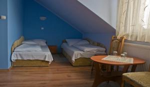 niebieski pokój z 2 łóżkami i stołem w obiekcie Hotel Czardasz we Wrześni +14 zdjęć