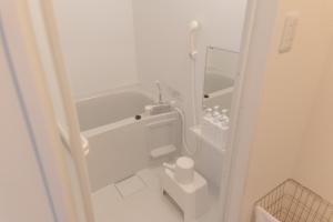 ein kleines weißes Badezimmer mit Toilette und Badewanne in der Unterkunft RIVER VILLAS HIROSHIMA - Vacation STAY 24194v in Hiroshima + 24 Fotos