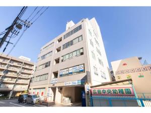 ein hohes Gebäude mit einem davor geparkt in der Unterkunft RIVER VILLAS HIROSHIMA - Vacation STAY 24194v in Hiroshima