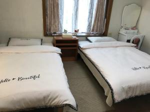 two beds sitting in a room with a mirror at Family House "2F" - Vacation STAY 12940 in Kumamoto