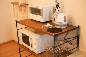 a microwave and a toaster oven on a table with wine glasses at NAGI - Vacation STAY 41896v in Nanjo