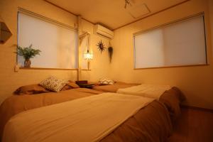 two beds in a room with a window at NAGI - Vacation STAY 41896v in Nanjo