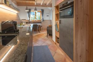 a kitchen with a stainless steel refrigerator and a table at Dorfchalets - Chalet Cenzi inkl Tauern Spa Eintritt & Sommerkarte in Kaprun