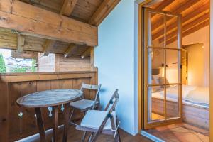 a room with a table and a bed and a bedroom at Dorfchalets - Chalet Cenzi inkl Tauern Spa Eintritt & Sommerkarte in Kaprun +11 photos