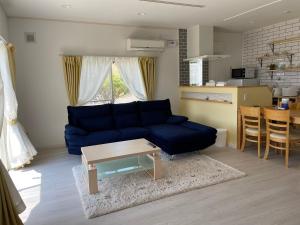 ein Wohnzimmer mit einem blauen Sofa und einem Tisch in der Unterkunft Holiday Villa Ta-View - Vacation STAY 45517v in Kose
