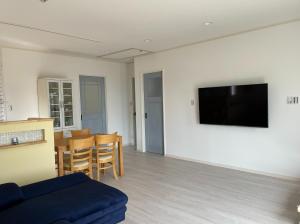 ein Wohnzimmer mit einem Sofa und einem Fernseher an der Wand in der Unterkunft Holiday Villa Ta-View - Vacation STAY 45517v in Kose