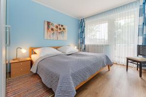 a blue bedroom with a bed and a chair at Haus Baltic Ostseeidylle in Scharbeutz