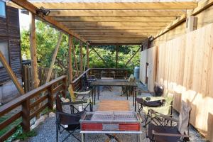 eine Terrasse mit Tischen und Stühlen und einer Holzdecke in der Unterkunft Cottage Coliberty - Vacation STAY 60526v in Anan