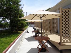a patio with tables and umbrellas on a building at Villa House Hisago - Vacation STAY 61410v in Kawazu +16 photos