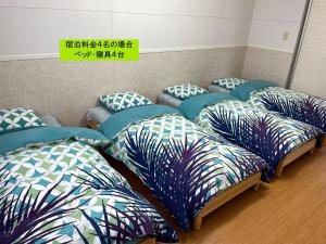 a row of beds with pillows in a room at Elegance Kukou Minami B - Vacation STAY 12934 in Miyazaki