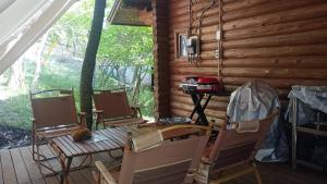 porche con 4 sillas, mesa y fogones en BROWN LOG - Vacation STAY 54364v, en Yamanakako