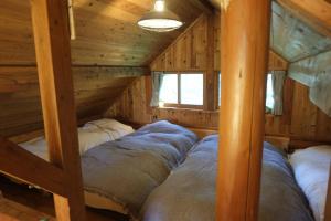 Un dormitorio con dos camas en una cabaña de madera. en BROWN LOG - Vacation STAY 54364v, en Yamanakako