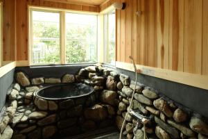 a bathroom with a stone sink in a rock wall at Higashichichibu-mura Kominka - Vacation STAY 59627v in Minano
