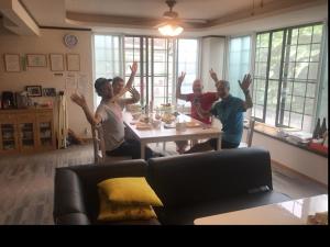a group of people sitting around a table with their hands up at Misato Memorial Hall - Vacation STAY 61405v in Hirakawa