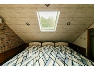 a bedroom with a bed with two chairs and a window at Log House Seseragi - Vacation STAY 62500v in Tsuru  +83 photos