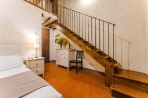 a bedroom with a staircase and a bed and a desk at Casone Ugolino in Donoratico