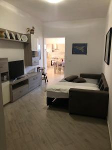 a bedroom with a bed and a couch and a kitchen at Casa Donatella a Isola in Isola delle Femmine