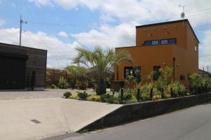 ein großes Orangengebäude mit Palmen davor in der Unterkunft east village torami - Vacation STAY 65943v in Ichigaya