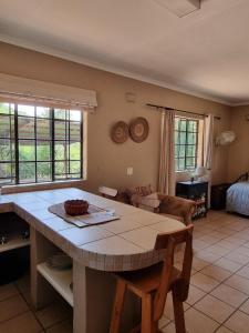 eine Küche mit einem Tisch und ein Wohnzimmer in der Unterkunft Mackers Self Catering Cottages in Hazyview