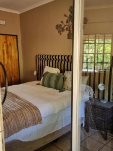 ein Schlafzimmer mit einem Bett und einem Fenster in der Unterkunft Mackers Self Catering Cottages in Hazyview