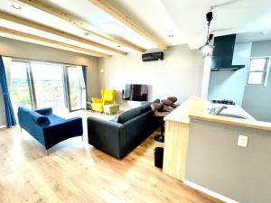 a living room with a black couch and a kitchen at BEACH HOUSE Kamogawa - Vacation STAY 64005v in Kamogawa