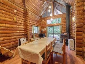 ein Esszimmer mit einem Tisch in einer Blockhütte in der Unterkunft Runesu Karuizawa - Vacation STAY 92241v in Tsumagoi