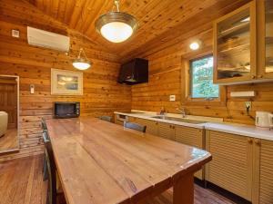 a kitchen with a large wooden table in a cabin at Runesu Karuizawa - Vacation STAY 92236v in Tsumagoi