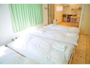 a group of white beds in a room at Konyamachi Guest House Kuku - Vacation STAY 80155v in Takamatsu