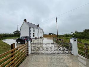 a car parked in front of a house on a flooded street at Castleroddy House in Lislap