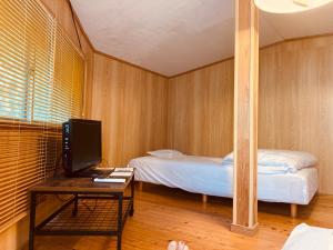a room with a bed and a desk with a tv at Guesthouse Nichinan - Vacation STAY 82905v in Nichinan