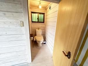 a small bathroom with a toilet and a window at Tiny Camp House Kurage - Vacation STAY 65999v in Kamijinoo +19 photos