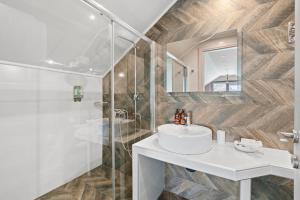 Un baño con lavabo blanco y ducha. en Onar Villa, en Nikiana 25 fotos más