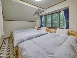 two twin beds in a room with a window at Runesu Karuizawa - Vacation STAY 78403v in Tsumagoi