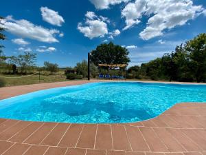 a pool with blue water and a gazebo at Gufo in Pitigliano