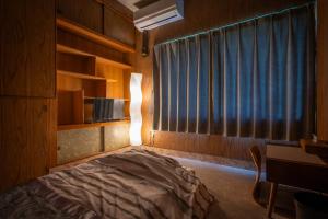a bedroom with a bed and a window and a desk at Chizu - Vacation STAY 83941v in Mitoyo