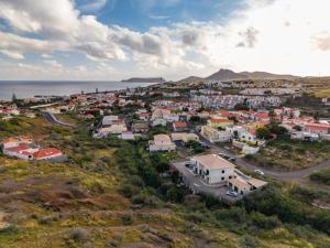 an aerial view of a town on a hill with the ocean at Simões Charm By HR Madeira in Vila Baleira