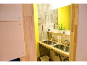 a kitchen with a sink and a yellow wall at Konyamachi Guest House Kuku - Vacation STAY 72725v in Takamatsu +33 photos