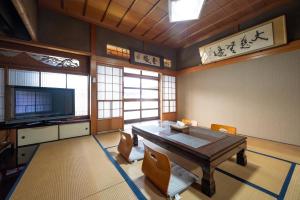 a dining room with a table and chairs and a television at Chizu - Vacation STAY 83974v in Mitoyo +5 photos