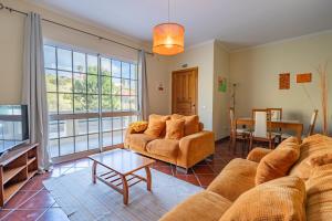 a living room with a couch and a table at Simões Charm By HR Madeira in Vila Baleira