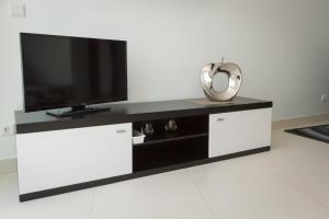 a white entertainment center with a flat screen tv at PeraLux in Pêra