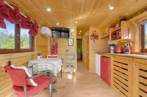 a kitchen and dining room in a log cabin at La Roulotte du Cagire - 4 pers - Pyrénées in Villeneuve-de-Rivière