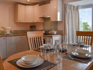a dining room table with plates and glasses on it at Uk47758 - Horseshoe Cottage in Launceston +17 photos