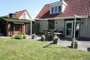 a house with a patio with a table and chairs at Kustverhuur, Park Schoneveld Stern 208 in Breskens