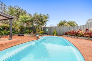 a swimming pool in a backyard with a fence at Zen Paradise in Coffs Harbour