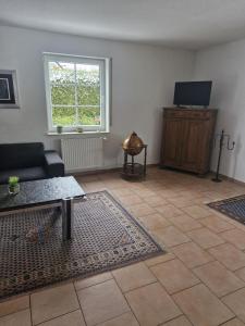 ein Wohnzimmer mit Sofa und Fernseher in der Unterkunft Dat Steenhus - Haustiere Willkommen in Marienhafe