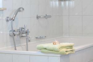 ein Badezimmer mit einer Badewanne und Handtüchern darauf in der Unterkunft Dat Steenhus - Haustiere Willkommen in Marienhafe + 14 Fotos