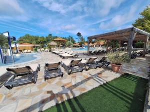 a group of reclining chairs sitting next to a pool at Mobil Home 6 personnes in Biscarrosse