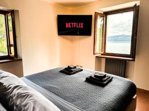 Postel nebo postele na pokoji v ubytování Stresa vista lago con CINEMA e SPIAGGIA
