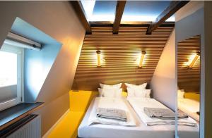 a small room with two beds in a room with a window at Design Apartments Haus Noge in Westerland (Sylt)
