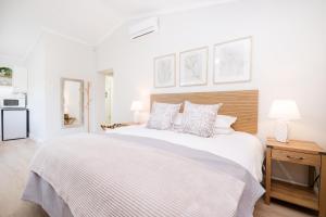 a white bedroom with a large white bed with pillows at 10VDW Self Catering Apartments-Newly Renovated! in Durbanville